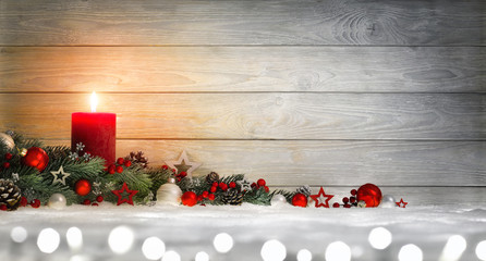Hintergrund für Weihnachten oder Advent mit Holz, Kerze, Lichtern und Dekoration auf Schnee