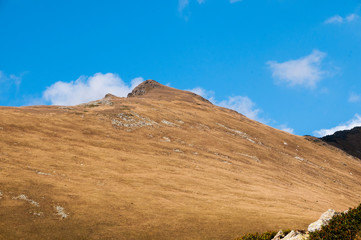 mountain autumn slope without trees on a Sunny day.