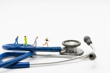 Miniature people running stethoscope. Health care and medical.