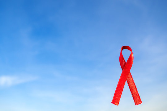 Aids Awareness Sign red ribbon with copy space for add text on blue sky background. World Aids Day December 1 concept