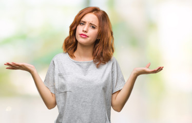 Young beautiful woman over isolated background clueless and confused expression with arms and hands...