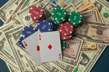 Poker chips on dollars and two aces