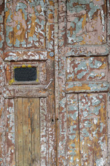 Old wooden weathered door with the old paint flaking