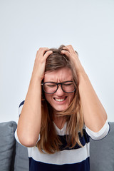 Young woman with headache / pain holding head.