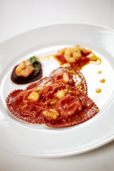 Heart shaped fresh stuffed pasta dressed with shrimps cream. Valentine's festive dish.