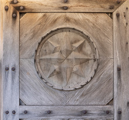 Wooden star on an old wooden weathered Catholic church door in Western Ukraine