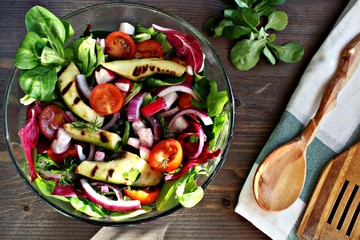 Avacodo and tomotos grilled salad vegeterian with wooden spoon