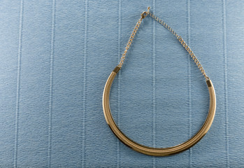 gold chain jewelry on blue background