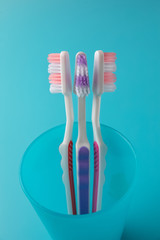 toothbrushes on a blue background in a blue glass