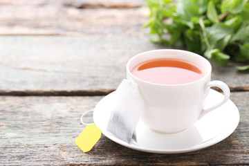 Cup of tea with teabag on grey wooden table