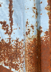 Multicolored background: rusty metal surface with blue paint flaking and cracking texture