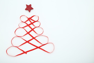 Red ribbon in shape of christmas tree on white background