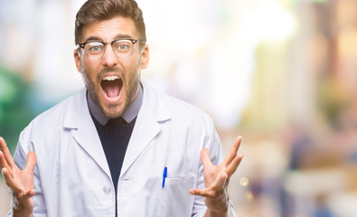 Young handsome man wearing doctor, scientis coat over isolated background crazy and mad shouting...