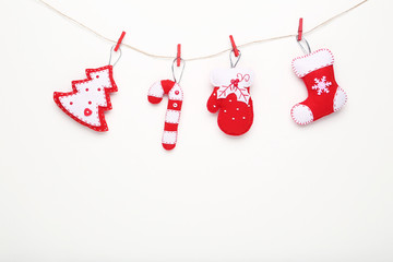 Soft christmas toys hanging on white background