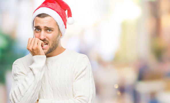 Young handsome man wearing santa claus hat over isolated background looking stressed and nervous with hands on mouth biting nails. Anxiety problem.