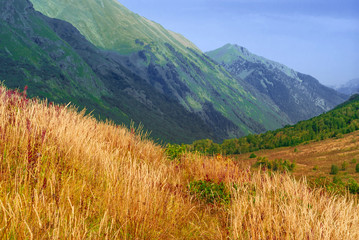 beautiful sunny mountain valley with autumn grass in the foreground
