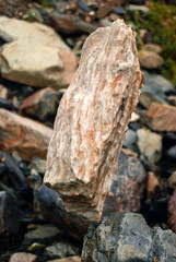 light natural cobblestone stands vertically in delicate balance on another stone