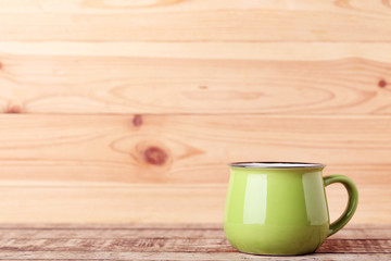 Green mug on brown wooden table