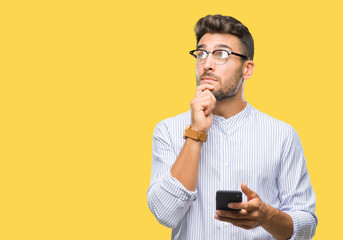 Young handsome man texting using smartphone over isolated background serious face thinking about...