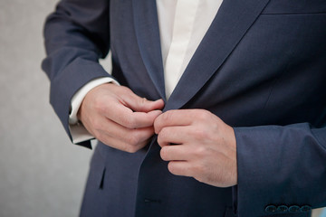 the man buttoning hands a jacket