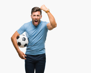 Young handsome man holding soccer football ball over isolated background annoyed and frustrated...