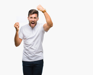 Young handsome man holding blank card over isolated background annoyed and frustrated shouting with anger, crazy and yelling with raised hand, anger concept
