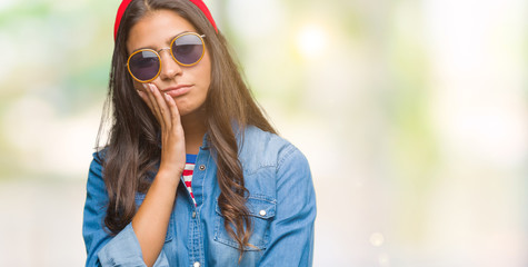 Young beautiful arab woman wearing sunglasses over isolated background thinking looking tired and bored with depression problems with crossed arms.