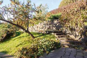 Fototapeta na wymiar Cottage garden with stone stairs and retaining wall