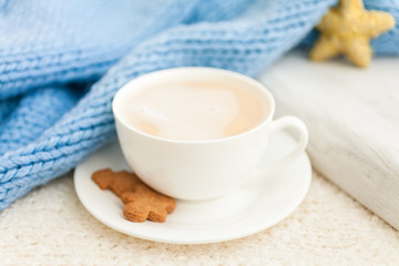 Cup of hot coffee with christmas gingerbread cookie man, traditional holiday sweet. Winter background