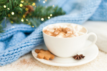 Cup of hot coffee with christmas gingerbread cookie man and marshmallows, traditional holiday sweet. Winter background