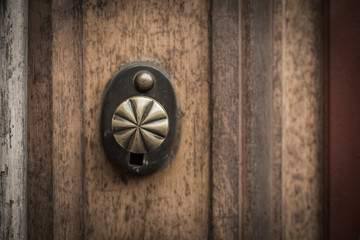 Old wooden door with round bronze handle.