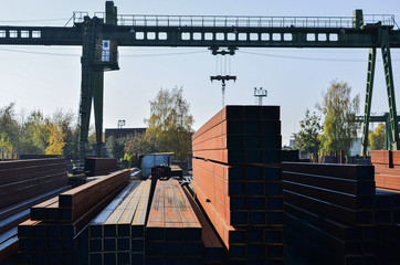 Warehouse of metal products, metal, on the background of a gantry crane on an industrial site