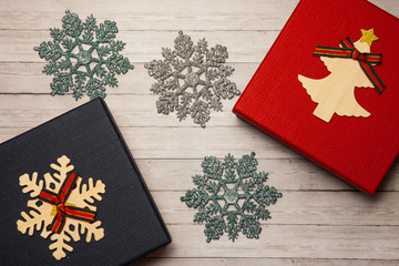 Gift box of red and blue on a wooden background with snowflakes, close-up