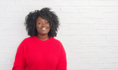 Young african american plus size woman over white brick wall with a happy and cool smile on face. Lucky person.