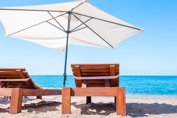 Fototapeta premium White lounge chairs on a beautiful tropical beach at Maldives