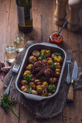 Baked octopus and garlicy potatoes in a tray