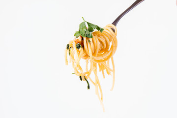 Spaghetti Carbonara with some parsley on a fork on a white background