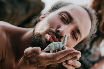 Guy with cute sauropod toy on the beach © Gardinovacki