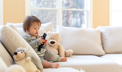 Little toddler boy with a TV remote control