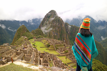 One female tourist looking at the famous ancient Inca ruins of Machu Picchu, Cusco region, Peru 