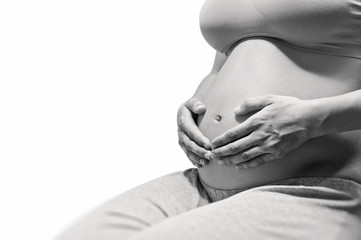 Black and white image of a beautiful pregnant woman. She hugging the tummy. Concept of happy pregnancy.