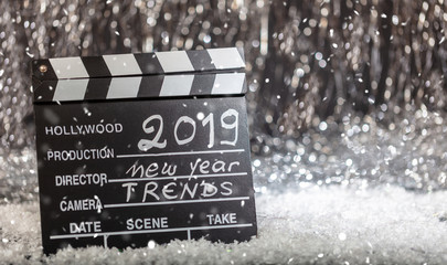 New year 2019 trends on movie clapper, abstract bokeh lights background