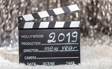 New year 2019 on movie clapper, abstract bokeh lights background