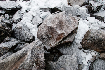 Ice and granite rocks on the beach