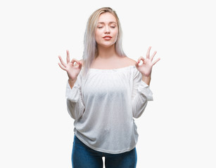Fototapeta premium Young blonde woman over isolated background relax and smiling with eyes closed doing meditation gesture with fingers. Yoga concept.
