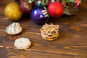 Christmas gingerbread cookies on a wooden table decorated with a garland on a wooden background, top view. Space for space