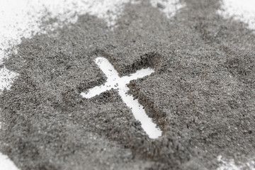Christian cross or crucifix drawing in ash, dust or sand as symbol of religion, sacrifice, redemtion, Jesus Christ, ash wednesday, Ash Wednesday concept