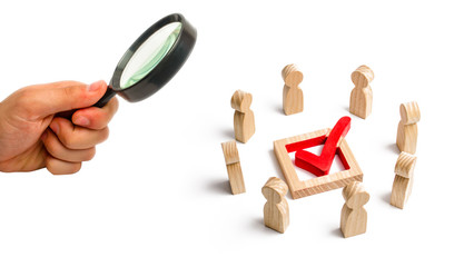 Fototapeta premium People stand in a circle and look at the check mark in the box. election, poll or referendum. Poll people. Voters participate in elections of parliament. Decision making, teamwork. Selective focus