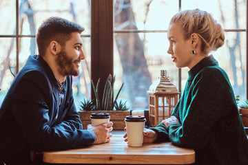 Romantic couple in the cafe is drinking coffee and talking. 