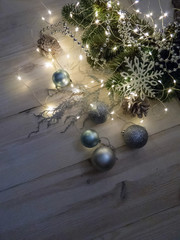Winter still life with garland, balls, pine and cones on a white wooden background top view. christmas